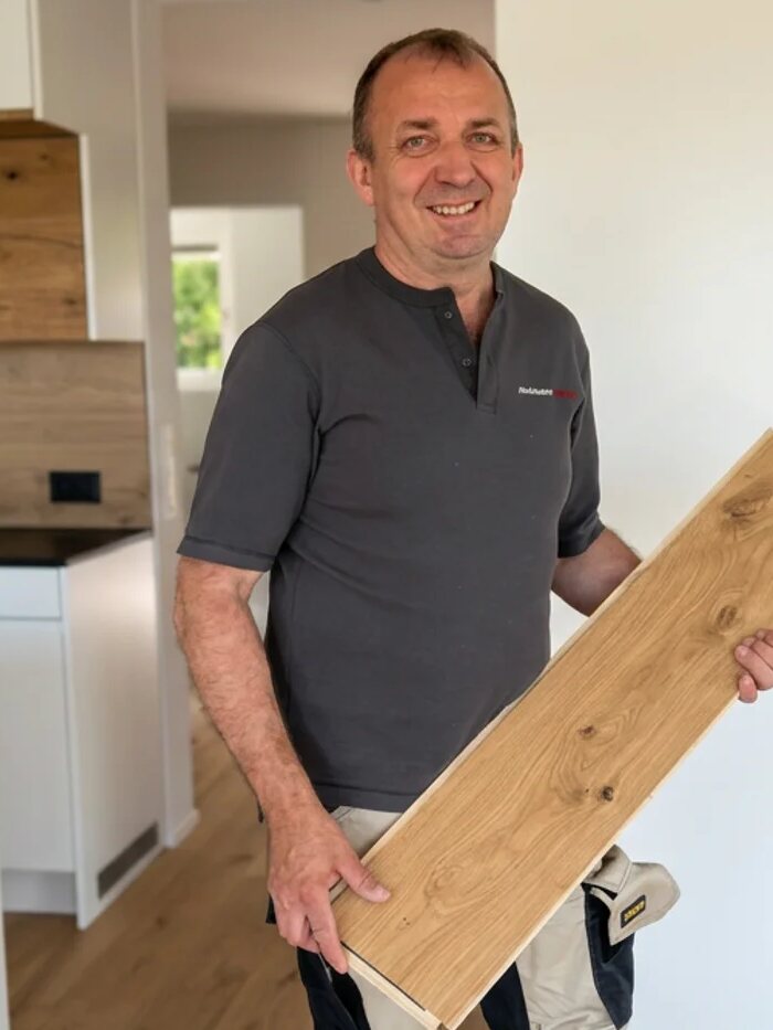 Daniel Stirnimann mit einer Holzdiele in der Hand